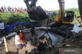 Pekerja mengangkat kepala arca Kala menggunakan alat berat dari sungai Desa Nambaan, Kediri, Jawa Timur, Minggu (12/6/2022). Dua buah kepala arca Kala yang diperkirakan peninggalan era kerajaan Kediri tersebut diangkat dari dasar sungai sebagai cara penyelamatan dan akan menjadi aset desa setempat guna membangun kawasan wisata sejarah. ANTARA Jatim/Prasetia Fauzani/zk