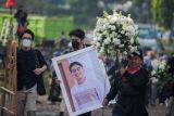 Keluarga Gubernur Jawa Barat Ridwan Kamil membawa foto almarhum Emmeril Kahn Mumtadz sebelum prosesi pemakaman di Cimaung, Banjaran, Kabupaten Bandung, Jawa Barat, Senin (13/6/2022). Emmeril Kahn dimakamkan di lokasi yang akan dijadikan Islamic Center Al Mumtadz yang di desain sendiri oleh Ridwan Kamil. ANTARA FOTO/Raisan Al Farisi/nym.