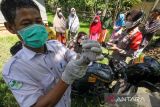 Petugas layanan motor vaksinasi COVID-19 Bhabinkamtibmas Polsek Syamtalira Baru memeriksa kesehatan warga yang akan melakukan vaksinasi COVID-19 di Desa Glong, Aceh Utara, Aceh, Senin (13/6/2022). Polsek di jajaran Polres Lhokseumawe meluncurkan layanan jemput bola vaksinasi COVID-19 dengan sepeda motor ke desa-desa pedalaman yang tidak dapat dilalui kendaraan roda empat guna memberikan kemudahan kepada warga yang kesulitan mendatangi lokasi vaksinasi sekaligus untuk mendorong percepatan capaian vaksinasi COVID-19. ANTARA FOTO/Rahmad