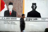 Seorang warga berjalan di dekat mural bergambar Presiden Joko Widodo di Kedung Halang, Kota Bogor, Jawa Barat, Senin (13/6/2022). Komisi Pemilihan Umum (KPU) akan memulai tahapan Pemilu 2024 dengan perencanaan program, anggaran dan penyusunan peraturan pelaksanaan pemilu serta mulai menghitung mundur menuju hari pemungutan suara pemilu yang telah ditetapkan pada Rabu 14 Februari 2024. ANTARA FOTO/Arif Firmansyah/nym.