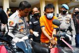 Kapolres Madiun Kota AKBP Suryono (kiri) melihat tersangka FM memraktikkan cara mencuri sepeda motor saat merilis pengungkapan kasus pencurian sepeda motor di Kota Madiun, Jawa Timur, Rabu (15/6/2022). Tersangka FM asal Wonogiri Jawa Tengah tersebut menggunakan pucuk gunting sebagai kunci kontak palsu untuk menghidupkan mesin dan membawa kabur dua unit sepeda motor hasil curiannya. ANTARA Jatim/Siswowidodo/zk