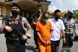 Polisi membawa tersangka AB (tengah) saat merilis pengungkapan kasus pembunuhan di Kota Madiun, Jawa Timur, Rabu (15/6/2022). ersangka AB menggunakan celurit membunuh Aris Budianto yang baru sehari pensiun dari pegawai RRI Madiun diduga berlatar belakang masalah pribadi pada 2 Juni 2022. ANTARA Jatim/Siswowidodo/zk