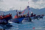 Warga mengiringi prosesi Labuh Laut/Larung Sembonyo dengan menumpang perahu nelayan yang beroperasi di Pelabuhan Perikanan Nusantara (PPN) Prigi, Trenggalek, Jawa Timur, Sabtu (18/6/2022). Prosesi adat dengan ritual melarung sesaji ke tengah laut itu ramai diikuti warga dan wisatawan yang 'haus' hiburan dan tontotan pascapebatasan sosial selama pandemi COVID-19, dua tahun terakhir. ANTARA Jatim/Destyan Sujarwoko/zk