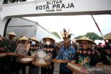 Menteri Koperasi dan UKM Teten Masduki (Tengah) didampingi Wakil Walikota Blitar Tjutjuk Sunario (Kanan) dan PJ Bupati Lany Jaya Petrus Wakerkwa (Dua Kanan) memainkan alat penumbuk padi tradisional saat pembukaan Bazar Blitar Jaman Doeloe (Jadoel) didepan aloon-aloon Kota Blitar, Jawa Timur, Jumat (17/6/2022). Bazar Blitar Jadoel yang rencananya berlangsung hingga tanggal 21 Juni mendatang tersebut diikuti oleh ratusan pengusaha mikro (UMKM) lokal dan dari sejumlah daerah di jawa serta papua. ANTARA Jatim/Irfan Anshori/zk