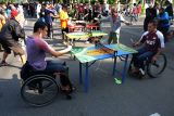 Warga bermain tenis meja mini saat kegiatan Hari Bebas Kendaraan Bermotor atau Car Free Day (CFD) di Solo, Jawa Tengah, Minggu (19/6/2022). Permainan tenis meja mini yang disediakan gratis tersebut merupakan salah satu sarana olahraga yang banyak digemari warga saat pelaksanaan CFD di Solo. ANTARA FOTO/Maulana Surya/foc.