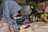 Warga mengakses internet wifi prabayar menggunakan telepon pintar di Dusun Bandaruka, Desa Karanganyar, Kabupaten Ciamis, Jawa Barat, Selasa (21/6/2022). Warga Dusun Bandaruka dan Karanganyar terpaksa mengakses internet di Pos Ronda akibat kesulitan mendapatkan jaringan internet dan telepon, dan berharap kepada pemerintah daerah dapat memberikan solusi supaya bisa melek informasi dan komunikasi. ANTARA FOTO/Adeng Bustomi/agr
