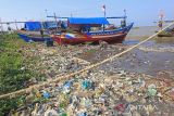 Nelayan memperbaiki perahu di sekitar pantai yang dipenuhi sampah plastik di Juntinyuat, Indramayu, Jawa Barat, Rabu (22/6/2022). Pemerintah Indonesia berkomitmen untuk mengurangi sampah plastik di laut dengan diterbitkannya Rencana Aksi Nasional Penanganan Sampah Plastik Laut dan menargetkan pengurangan sebesar 70 persen di tahun 2025. ANTARA FOTO/Dedhez Anggara/agr