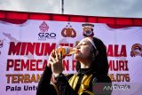 Seorang personel Polda Maluku minum jus pala bersama-sama saat pemecahan rekor Museum Rekor Dunia Indonesia (MURI) untuk minum 16.076 botol jus pala, di Kota Ambon, Sabtu (25/6/2022). (ANTARA FOTO/FB Anggoro)