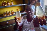 Seorang warga menunjukkan jus pala yang sudah dikemas di Negeri Morella, Kabupaten Maluku Tengah. Jus Pala merupakan minuman khas dari Negeri Morella yang memanfaatkan sari buah pala sebagai minuman menyegarkan dan dijual eceran di Kota Ambon Rp10 ribu per botol. (ANTARA FOTO/FB Anggoro)