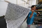 Pekerja menyelesaikan pembuatan batik printing untuk bahan seragam sekolah di Indramayu, Jawa Barat, Jumat (8/7/2022). Jelang tahun ajaran baru 2022/2023, permintaan seragam batik dari berbagai daerah di Jabar meningkat hingga 60 persen dengan harga Rp60 ribu hingga Rp150 ribu per pasang. ANTARA FOTO/Dedhez Anggara/agr