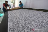 Pekerja menyelesaikan pembuatan batik 