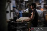 Pekerja mengangkut tahu hasil produksi di Cisaranten Wetan, Bandung, Jawa Barat, Rabu (13/7/2022). Berdasarkan data hingga Juni 2022, Perum Bulog telah menyalurkan sebanyak 28.728 ton kedelai subsidi di 16 provinsi yang di salurkan melalui Koperasi Produsen Tahu dan Tempe Indonesia (KOPTI) sebagai upaya menjaga keberlangsungan usaha dan meningkatkan minat perajin tahu dan tempe agar tetap berproduksi. ANTARA FOTO/Raisan Al Farisi/agr