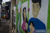 Warga berkumpil di dekat mural keluarga berkualitas di Kampung KB dan Budaya Kaligrafi di Bandung, Jawa Barat, Rabu (13/7/2022). Pemerintah segera mengoptimalisasi penyelenggaraan Inpres No 3 Tahun 2022 tentang kampung keluarga berkualitas pada tingkat desa dan kelurahan sebagai acuan dalam membangun ketahanan keluarga. ANTARA FOTO/Novrian Arbi/agr