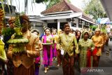  Wali Kota Madiun Maidi (tengah) bersama isteri Yuni Maidi (kedua kanan) berjalan bersama sejumlah pengantin saat nikah massal di Rumah Dinas Wali Kota Madiun, Jawa Timur, Kamis (14/7/2022). Pemkot Madiun memfasilitasi pernikahan secara gratis sembilan pasangan pengantin dalam rangkaian peringatan Hari Jadi ke-104 Kota Madiun. ANTARA Jatim/Siswowidodo/Zk