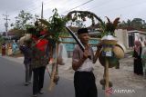 Warga Suku Osing membawa engklek seserahan pengantin di Desa Kemiren, Banyuwangi, Jawa Timur, Kamis (14/7/2022). Arak-arakan pengantin yang melibatkan warga dengan berbagai kesenian khas seperti Barong, Macanan, Jaran Kencak dan pitik-pitikan tersebut merupakan tradisi Suku Osing Kemiren yang hingga saat ini masih dilestarikan. ANTARA Jatim/Budi Candra Setya/zk