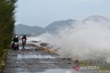 Kendaraan melintasi jalan pantai saat berlangsung gelombang tinggi di daerah pesisir Kampung Jawa, Banda Aceh, Aceh, Jumat (15/7/2022). Badan Meteorologi, Klimatologi dan Geofisika (BMKG) memperingatkan kapal nelayan, kapal tongkang, kapal ferry, kapal kargo serta kapal pesiar agar mewaspadai tinggi gelombang 1,25 hingga 2,50 meter di perarian Selat Melaka, sedangkan tinggi gelombang  2,50 hingga 4 meter di perairan Utara Sabang, perarian Barat Aceh, perarian Pulau Simeulue dan Samudera Hindia Barat Aceh hingga kepulauan Nias yang berpeluang terjadi hingga tanggal 17 Juli 2022. ANTARA FOTO/Ampelsa.