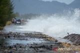 Kendaraan melintasi jalan pantai saat berlangsung gelombang tinggi di daerah pesisir Kampung Jawa, Banda Aceh, Aceh, Jumat (15/7/2022). Badan Meteorologi, Klimatologi dan Geofisika (BMKG) memperingatkan kapal nelayan, kapal tongkang, kapal ferry, kapal kargo serta kapal pesiar agar mewaspadai tinggi gelombang 1,25 hingga 2,50 meter di perarian Selat Melaka, sedangkan tinggi gelombang  2,50 hingga 4 meter di perairan Utara Sabang, perarian Barat Aceh, perarian Pulau Simeulue dan Samudera Hindia Barat Aceh hingga kepulauan Nias yang berpeluang terjadi hingga tanggal 17 Juli 2022. ANTARA FOTO/Ampelsa.