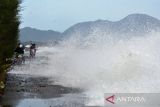 Kendaraan melintasi jalan pantai saat berlangsung gelombang tinggi di daerah pesisir Kampung Jawa, Banda Aceh, Aceh, Jumat (15/7/2022). Badan Meteorologi, Klimatologi dan Geofisika (BMKG) memperingatkan kapal nelayan, kapal tongkang, kapal ferry, kapal kargo serta kapal pesiar agar mewaspadai tinggi gelombang 1,25 hingga 2,50 meter di perarian Selat Melaka, sedangkan tinggi gelombang  2,50 hingga 4 meter di perairan Utara Sabang, perarian Barat Aceh, perarian Pulau Simeulue dan Samudera Hindia Barat Aceh hingga kepulauan Nias yang berpeluang terjadi hingga tanggal 17 Juli 2022. ANTARA FOTO/Ampelsa.