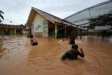 Sejumlah anak bermain air saat banjir menggenangi SDN 98 Kota Jambi di Kota Baru, Jambi, Jumat (15/7/2022). Sejumlah rumah dan bangunan sekolah di beberapa kecamatan di kota itu terendam banjir hingga 80 sentimeter setelah diguyur hujan lebat selama lebih dari 4 jam. ANTARA FOTO/Wahdi Septiawan/foc.