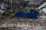 Warga mencuci pakaian yang terendam lumpur akibat banjir bandang Sungai Cimanuk di Garut, Jawa Barat, Sabtu (16/7/2022). Ratusan rumah rusak berat serta ratusan jiwa dari delapan kecamatan di Garut terdampak banjir bandang akibat luapan Sungai Cimanuk saat intensitas curah hujan yang tinggi pada Jumat (15/7) kemarin. ANTARA FOTO/Novrian Arbi/agr
