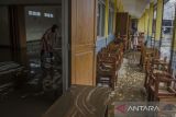 Dua orang guru membersihkan ruangan kelas yang terendam lumpur akibat banjir bandang Sungai Cimanuk di Sekolah PGRI Garut, Jawa Barat, Sabtu (16/7/2022). Banjir bandang akibat luapan Sungai Cimanuk saat intensitas curah hujan yang tinggi pada Jumat (15/7) kemarin mengakibatkan sejumlah sekolah hingga rumah ibadah rusak berat. ANTARA FOTO/Novrian Arbi/agr
