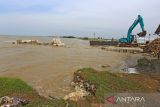 Pekerja menggunakan alat berat untuk menyusun batu beton pemecah ombak di pantai Dadap, Juntinyuat, Indramayu, Jawa Barat, Senin (18/7/2022). Kementerian Pekerjaan Umum dan Perumahan Rakyat (PUPR) melalui Balai Besar Wilayah Sungai Cimanuk-Cisanggarung (BBWS) melakukan penanganan abrasi pantai yang mengancam permukiman warga di daerah itu dengan membangun tanggul geobox sepanjang 4 km. ANTARA FOTO/Dedhez Anggara/agr