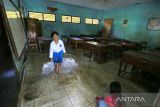 Anak-anak bermain air saat banjir menggenangi SDN 02 Pranggong, Kecamatan Arahan, Indramayu, Jawa Barat, Senin (18/7/2022). Pihak sekolah terpaksa meliburkan siswanya pada hari pertama masuk sekolah karena sejumlah ruang kelas terendam banjir akibat luapan sungai Cipelang. ANTARA FOTO/Dedhez Anggara/agr