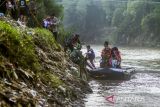 Tim SAR gabungan membantu pelajar turun dari perahu karet setelah menyebrangi Sungai Cimanuk, Garut, Jawa Barat, Selasa (19/7/2022). Warga di kawasan tersebut terpaksa menggunakan perahu karet yang disediakan oleh Tim SAR gabungan Polri, TNI dan Badan Penanggulangan Bencana Daerah (BPBD) Garut untuk akses penyeberangan, khususnya untuk menuju sekolah setelah jembatan penghubung antarkecamatan dampak banjir bandang Sungai Cimanuk beberapa waktu lalu. ANTARA FOTO/Novrian Arbi/agr