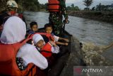 Tim SAR gabungan membawa pelajar menggunakan perahu karet untuk menyebrangi Sungai Cimanuk, Garut, Jawa Barat, Selasa (19/7/2022). Warga di kawasan tersebut terpaksa menggunakan perahu karet yang disediakan oleh Tim SAR gabungan Polri, TNI dan Badan Penanggulangan Bencana Daerah (BPBD) Garut untuk akses penyeberangan, khususnya untuk menuju sekolah setelah jembatan penghubung antarkecamatan dampak banjir bandang Sungai Cimanuk beberapa waktu lalu. ANTARA FOTO/Novrian Arbi/agr