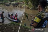 Tim SAR gabungan menggunakan perahu karet untuk membawa warga dan pelajar menyeberangi Sungai Cimanuk, Garut, Jawa Barat, Selasa (19/7/2022). Warga di kawasan tersebut terpaksa menggunakan perahu karet yang disediakan oleh Tim SAR gabungan Polri, TNI dan Badan Penanggulangan Bencana Daerah (BPBD) Garut untuk akses penyeberangan, khususnya untuk menuju sekolah setelah jembatan penghubung antarkecamatan dampak banjir bandang Sungai Cimanuk beberapa waktu lalu. ANTARA FOTO/Novrian Arbi/agr