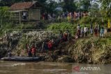 Warga mengantre untuk menyebrangi Sungai Cimanuk menggunakan perahu karet di Garut, Jawa Barat, Selasa (19/7/2022). Warga di kawasan tersebut terpaksa menggunakan perahu karet yang disediakan oleh Tim SAR gabungan Polri, TNI dan Badan Penanggulangan Bencana Daerah (BPBD) Garut untuk akses penyeberangan, khususnya untuk menuju sekolah setelah jembatan penghubung antarkecamatan dampak banjir bandang Sungai Cimanuk beberapa waktu lalu. ANTARA FOTO/Novrian Arbi/agr