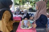 Petugas kesehatan menimbang berat badan anak saat berlangsung imunisasi di Posyandu, Kuta Alam, Banda Aceh, Aceh, Selasa (19/7/2022). Dinas Kesehatan Provinsi Aceh menyatakan, cakupan Imunisasi Dasar Lengkap (IDL) anak dalam lima tahun terakhir di daerah itu terus menurun  dan tercatat  tahun 2017 capaian imunisasi 59,7 persen, tahun 2018  turun menjadi 58 perrsen, tahun 2019 mencapai 48,9 persen, tahun 2020 mencapai 42,7 persen dan tahun 2021 turun lagi menjadi 38,4 persen akibat rendahnya kesadaran masyarakat terhadap pentingnya imuniasasi . ANTARA FOTO/Ampelsa.