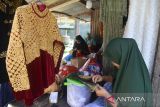 Perajin memasang hiasan payet dengan kombinasi sulaman benang emas pada pakaian penganten dan pakaian adat Aceh di Rumah Panggung Usaha Mikro Kecil dan Menengah (UMKM) Ida Payet, Desa Lambaro Neujid, Kabupaten Aceh Besar, Rabu (20/7/2022). Pelaku UMKM Ida Payet  yang mempekerjakan puluhan wanita perajin di daerah pesisir itu, menyatakan pemasaran produknya sejak dua tahun terakhir sudah berhasil menembus pasar nasional, bahkan Malaysia, namun kendalanya saat ini masih mengandalkan peralatan tradisional dan selain belum memiliki rumah UMKM. ANTARA FOTO/Ampelsa.