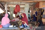 Perajin memasang hiasan payet dengan kombinasi sulaman benang emas pada pakaian penganten dan pakaian adat Aceh di Rumah Panggung Usaha Mikro Kecil dan Menengah (UMKM) Ida Payet, Desa Lambaro Neujid, Kabupaten Aceh Besar, Rabu (20/7/2022). Pelaku UMKM Ida Payet  yang mempekerjakan puluhan wanita perajin di daerah pesisir itu, menyatakan pemasaran produknya sejak dua tahun terakhir sudah berhasil menembus pasar nasional, bahkan Malaysia, namun kendalanya saat ini masih mengandalkan peralatan tradisional dan selain belum memiliki rumah UMKM. ANTARA FOTO/Ampelsa.