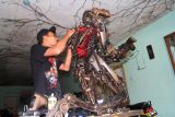 Perupa Khairul Mahmud menyelesaikan perakitan seni instalasi dari limbah plastik dan onderdil sepeda motor buatannya di Padang, Sumatera Barat, Selasa (19/7/2022). Seni instalasi yang dikerjakan sejak sebulan terakhir dengan memanfaatkan limbah buangan yang dikumpulkan dari sekitar tempat tinggalnya itu bertujuan sebagai media kampanye pemanfaatan limbah dan penyelamatan lingkungan. ANTARA FOTO/Muhammad Arif Pribadi/WS/hp.