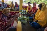 Warga menyajikan makanan kepada tetua adat untuk disantap bersama pada ritual Povunja atau syukuran setelah selesai masa panen di Sigi, Sulawesi Tengah, Kamis (21/7/2022). Sebagian masyarakat Suku Kaili sub etnis Ledo yang mendiami sebagian besar Lembah Palu, Sigi dan Donggala masih mempertahankan tradisi syukuran pascapanen itu dengan ritual-ritual adat sebagai bentuk terima kasih kepada Penguasa Alam. ANTARA FOTO/Basri Marzuki/nym.