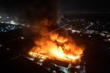 Foto udara kobaran api yang membakar kompleks pabrik pengolahan pupuk CV Saprotan Utama di Desa Bandungrejo, Mranggen, Demak, Jawa Tengah, Kamis (21/7/2022). Belum diketahui penyebab serta kerugian akibat terbakarnya pabrik tersebut, sementara sejumlah mobil pemadam kebakaran dikerahkan untuk memadamkan kobaran api. ANTARA FOTO/Aji Styawan/tom.