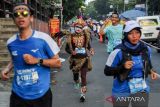 Peserta melintasi Jalan Phh Mustofa saat mengikuti Pocari Sweat Run Indonesia 2022 di Bandung, Jawa Barat, Minggu (24/7/2022). Pocari Sweat Run Indonesia 2022 tersebut diikuti secara serentak oleh 5.000 peserta dari 167 kota yang berlari secara luring di Kota Bandung dan 13.601 peserta di 311 kota seluruh Indonesia yang berlari secara daring. ANTARA FOTO/Raisan Al Farisi/agr
