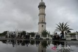 Sejumpah peserta olahraga bersepeda melintas di lokasi objek wisata Masjid Raya Baiturrahman  di  Banda Aceh, Aceh, Minggu (24/7/2022). Kegiatan olahraga bersepeda yang diikuti warga kota dan wistawan mengunjungi Museum Tsunami, PLTD Apung , Masjid Raya Baiturrahman dan beberapa objek wisata tsunami di pesisir pantai tersebut salah satu upaya untuk memperkenalkan dan mempromosikan sejumlah objek wsiata budaya dan situs sejarah di Aceh.  ANTARA FOTO/Ampelsa.