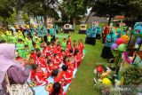 Anak-anak menyaksikan cerita dari kotak boneka pada Festival Posyandu Kreatif, Banyuwangi, Jawa Timur, Sabtu (23/7/2022). Festival tersebut selain digelar untuk menigkatkan inovasi para kader posyandu juga sebagai upaya pemerintah daerah setempat dalam percepatan pencegahan stunting. ANTARA Jatim/Budi Candra Setya/zk