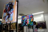 Pengunjung melihat lukisan yang terpampang dalam pameran seni rupa di salah satu pusat perbelanjaan Kabupaten Jombang, Jawa Timur, Sabtu (23/7/2022). Pameran seni rupa dengan tema 