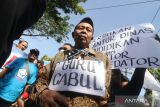 Pengunjuk rasa melakukan teatrikal saat aksi di depan Kantor Dinas Pendidikan, Kota Kediri, Jawa Timur, Senin (25/7/2022). Aksi gabungan dari sejumlah lembaga swadaya masyarakat tersebut menuntut agar oknum guru SD yang diduga telah mencabuli tujuh muridnya diberikan hukuman maksimal dan tidak selayaknya mendapatkan perlindungan dari Dinas Pendidikan. ANTARA ajtim/Prasetia Fauzani/zk