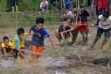 Sejumlah anak berpacu sambil menarik teman mereka menggunakan pelepah kelapa dan bambu saat memainkan 