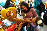 Juri melihat pertumbuhan gigi pada anak umur dibawah lima tahun (balita) saat Lomba Balita Sehat di Kota Madiun, Jawa Timur, Selasa (26/7/2022). Lomba yang diikuti 18 anak balita tersebut dimaksudkan untuk meningkatkan kemampuan dan pengetahuan orangtua dalam membina tumbuh kembang balita agar menjadi anak sehat dan cerdas, sekaligus menekan angka stunting. ANTARA Jatim/Siswowidodo/zk
