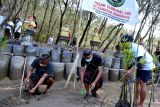 Warga menanam bibit mangrove di kawasan Mertasari, Denpasar, Bali, Selasa (26/7/2022). Penanaman mangrove tersebut dilakukan untuk memperingati Hari Mangrove Sedunia sekaligus sebagai aksi penolakan terhadap rencana pembangunan Terminal Liquefied Natural Gas (LNG) di kawasan mangrove setempat. ANTARA FOTO/Fikri Yusuf/nym.