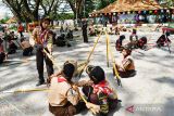 Sejumlah anggota Pramuka Penggalang menyelesaikan pembuatan tiang bendera menggunakan tongkat dan tali saat mengikuti lomba pionering di Ngrowo Bening Kota Madiun, Jawa Timur, Kamis (28/7/2022). Lomba yang diikuti 32 kelompok dari 16 sekolah tingkat SMP/MTs di Kota Madiun tersebut bertujuan utuk melatih kerja sama, kekompakan, kecepatan serta kejujuran anggota pramuka. ANTARA Jatim/Siswowidodo/zk