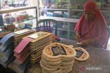 Perajin Samsyah (60 tahun) menyelesaikan kerajinan tangan  dari cangkang kerang di Kenjeran, Surabaya, Jawa Timur, Kamis (28/7/2022). Usaha kerajinan tangan yang berdiri sejak tahun 1988 tersebut menjadi cinderamata khas Pantai Kenjeran yang dijual dengan harga mulai Rp.25.000 hingga Rp.70.000 per buah tergantung model dan kerumitannya. ANTARA Jatim/Hildaniar Novitasari/ZK