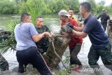 Prajurit Perhubungan Kodam Iskandar Muda bersama Balai Pelestarian Cagar Budaya Aceh, Masyarakat Peduli Sejarah Aceh (Mapesa) dan Polri mengangkat batu nisan yang terkubur dalam lumpur saat bakti sosial di lokasi situs sejarah Kerajaan Aceh Darussalam, Kampung Pande, Banda Aceh, Jumat (29/7/22). Bakti sosial tersebut untuk menyelamatkan dan penataan kembali ribuan batu nisan dan benda sejarah lainnya peninggal masa kerajaan Aceh Darussalam abad  ke-16 yang rusak dan terkubur dalam lumpur dampak dari bencana tsunami 26 Desember 2004. ANTARA FOTO/Ampelsa.