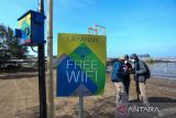 Warga menggunakan layanan wifi gratis di objek wisata Karangsong, Indramayu, Jawa Barat, Jumat (29/7/2022). Pemerintah Jawa Barat berkomitmen untuk memperluas jaringan internet hingga ke 5.300 desa di Jabar lewat Program Desa Digital. ANTARA FOTO/Dedhez Anggara/agr
