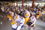 Umat Hindu mengikuti prosesi upacara potong gigi massal di Pura Jala Siddhi Amertha, Juanda, Sidoarjo, Jawa Timur, Sabtu (30/7/2022). Upacara potong gigi yang dalam bahasa Bali disebut Mepandes, Metatah, atau Mesangih itu diikuti 122 umat Hindu yang menginjak usia remaja atau dewasa dengan makna untuk menghilangkan keenam sifat buruk dari diri manusia. ANTARA Jatim/Umarul Faruq/zk